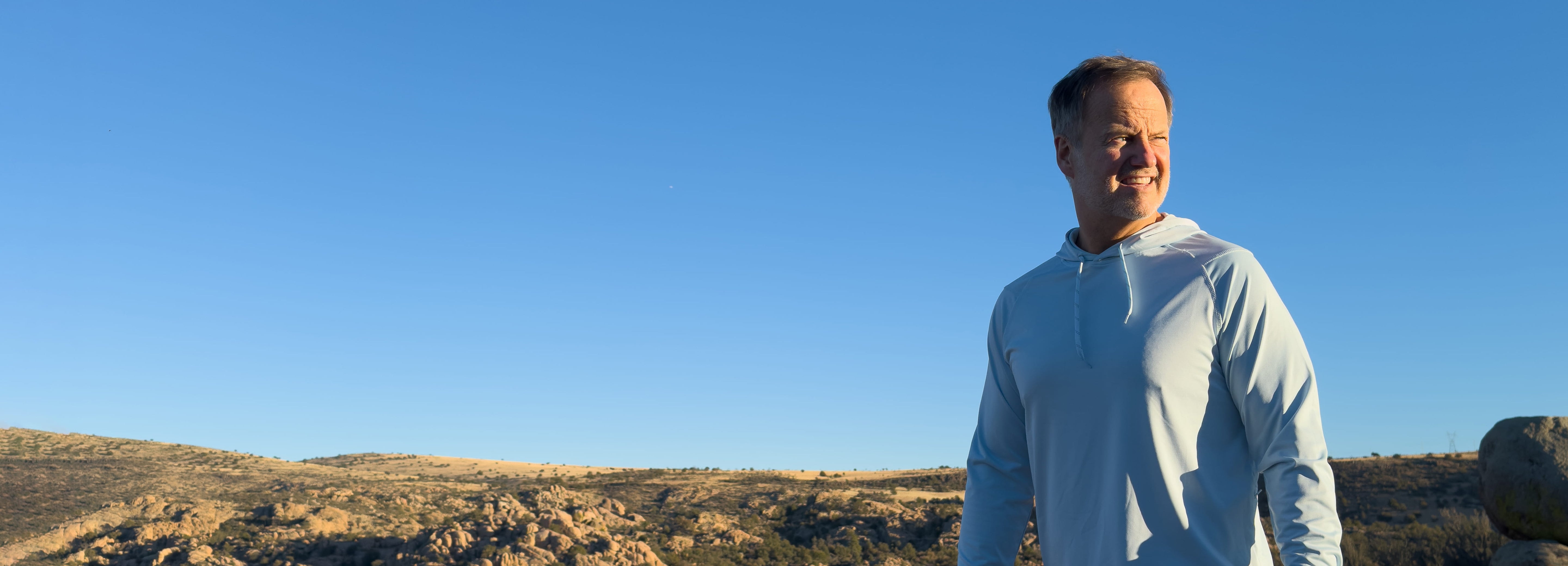 Man in a white hood standing in the sun