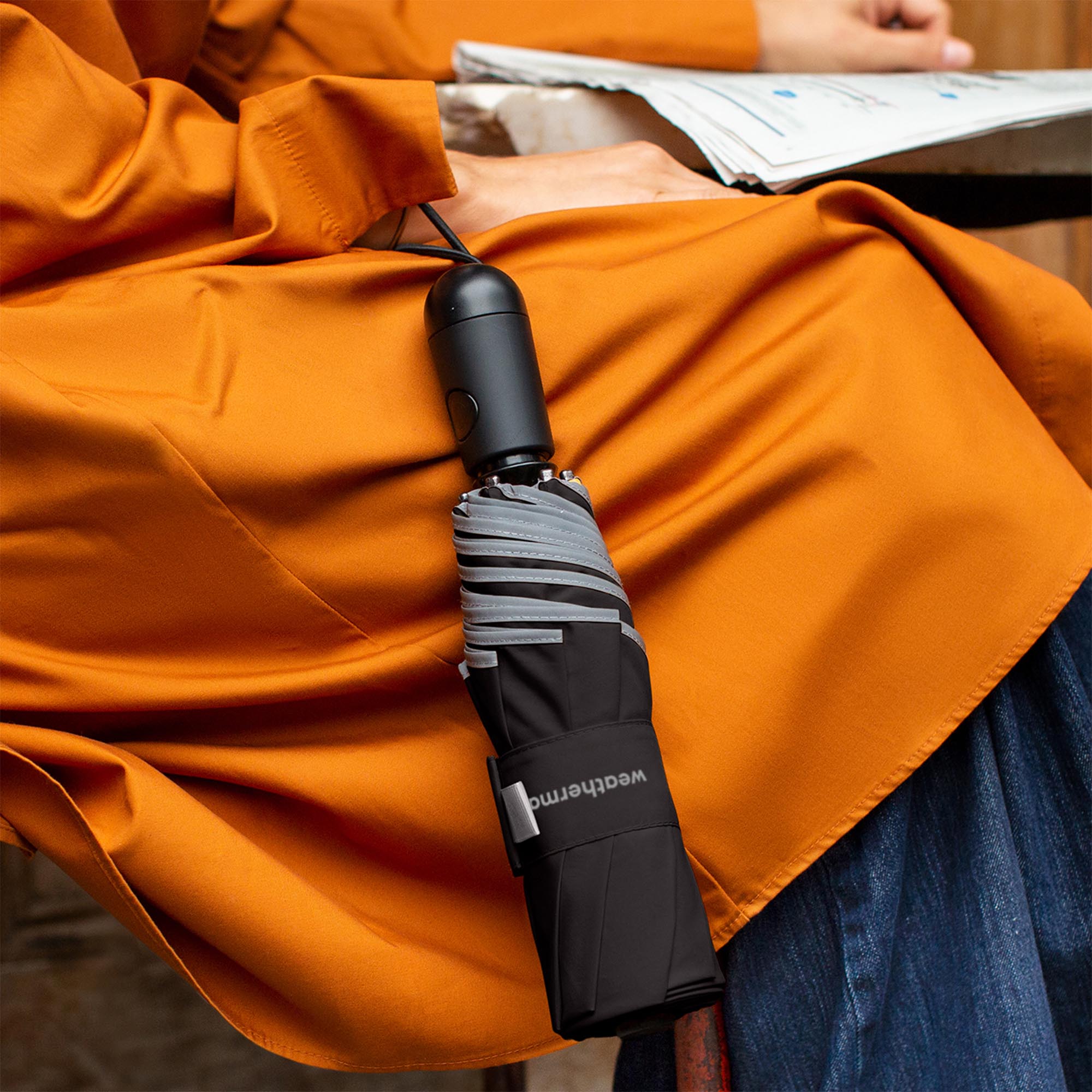 Person holding Weatherman Travel Umbrella in black.