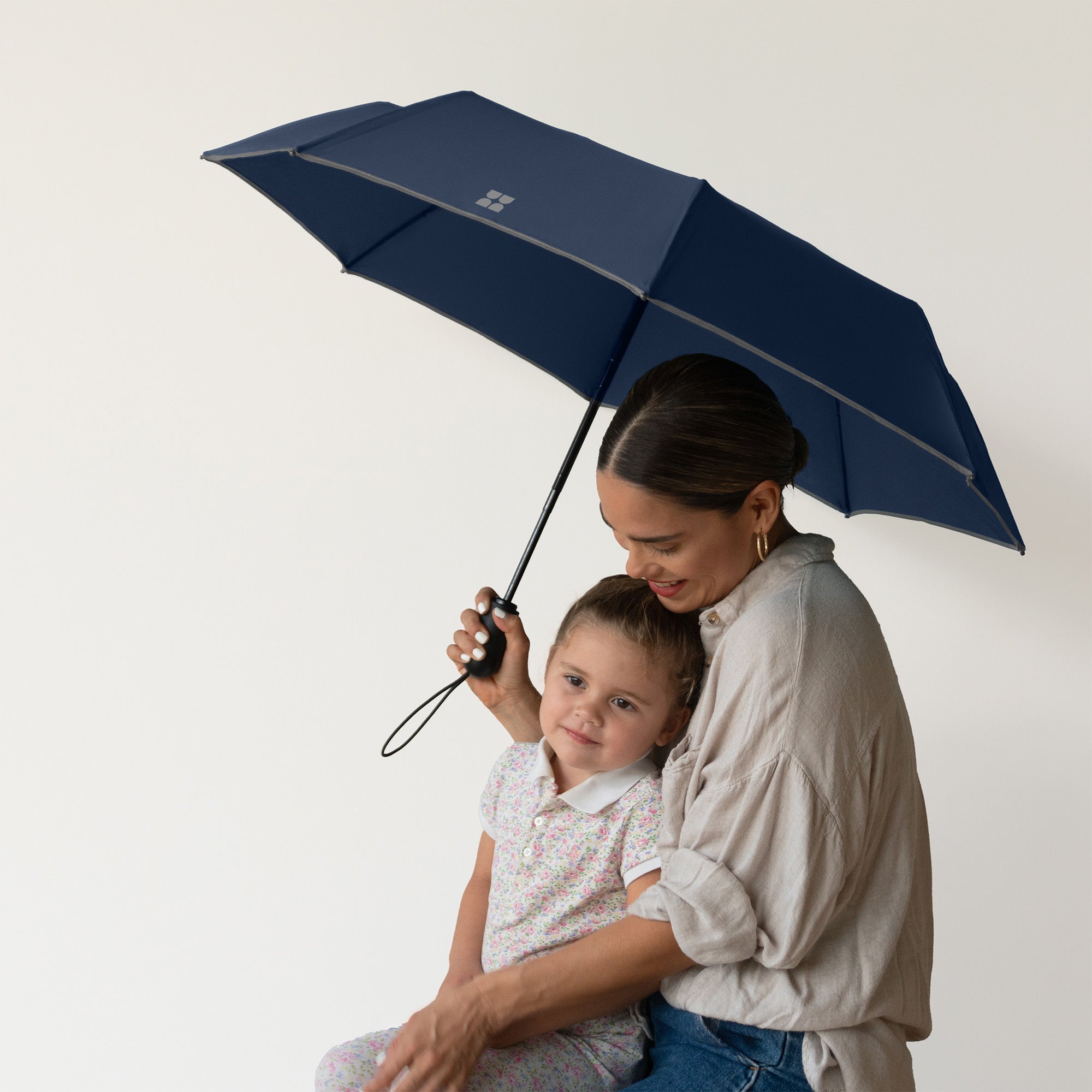Woman holding her child with Weatherman Travel Umbrella in navy.