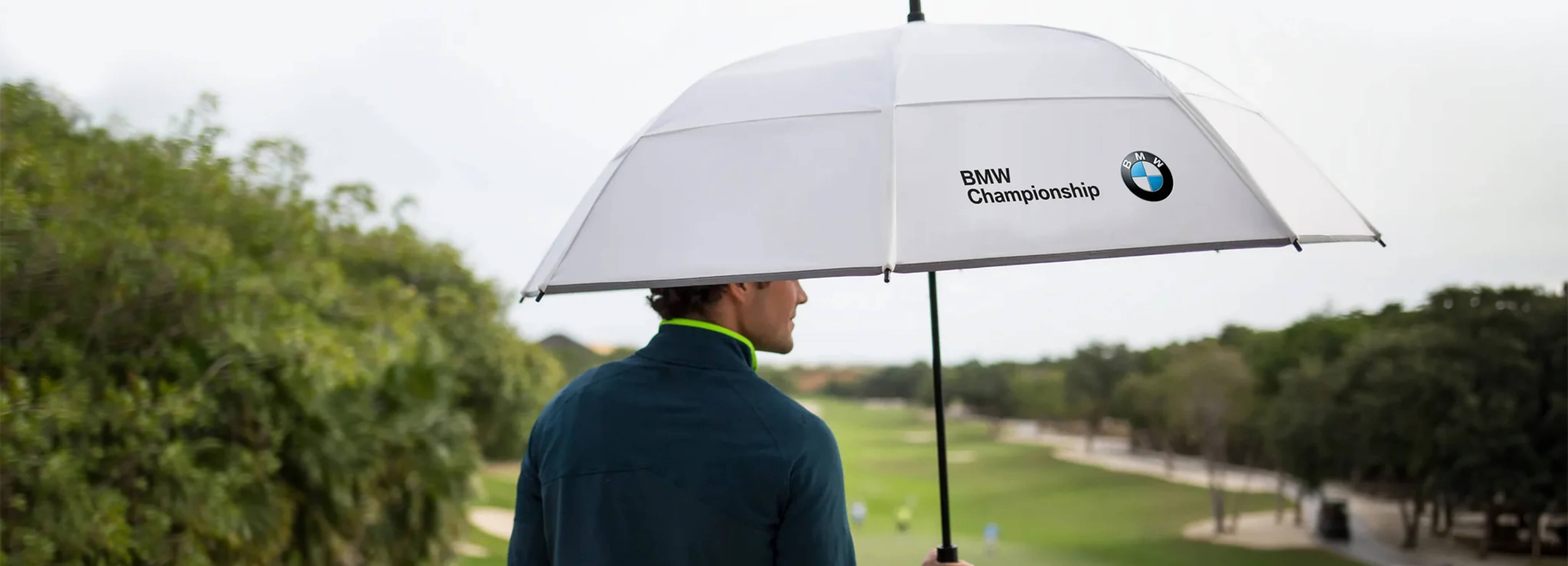 Man holding a BMW Championship umbrella