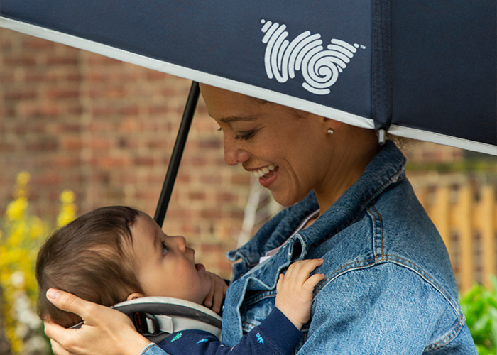 Woman smiling and holding child under Weatherman Collapsible Umbrella in navy blue.