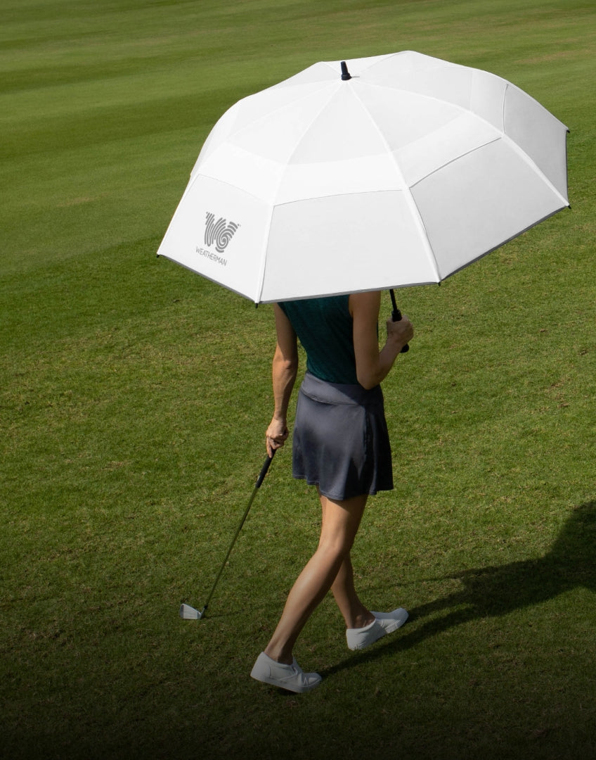 Woman with a golf umbrella on the ground