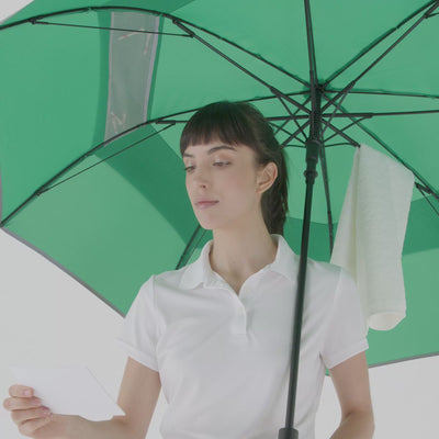 Woman using Weatherman Golf Umbrella mesh pocket to hole a scorecard.